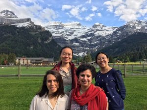 SHCN researchers pose for a group photo at the 2018 GRC on Industrial Ecology, swiss alps in the backgroud. Clockwise: SHCN post-doctoral researcher Lin Zeng, SHCN director Anu Ramaswami, SHCN post-doctoral researcher Dana Boyer, and SHCN post-doctoral researcher Kangkang Tong.