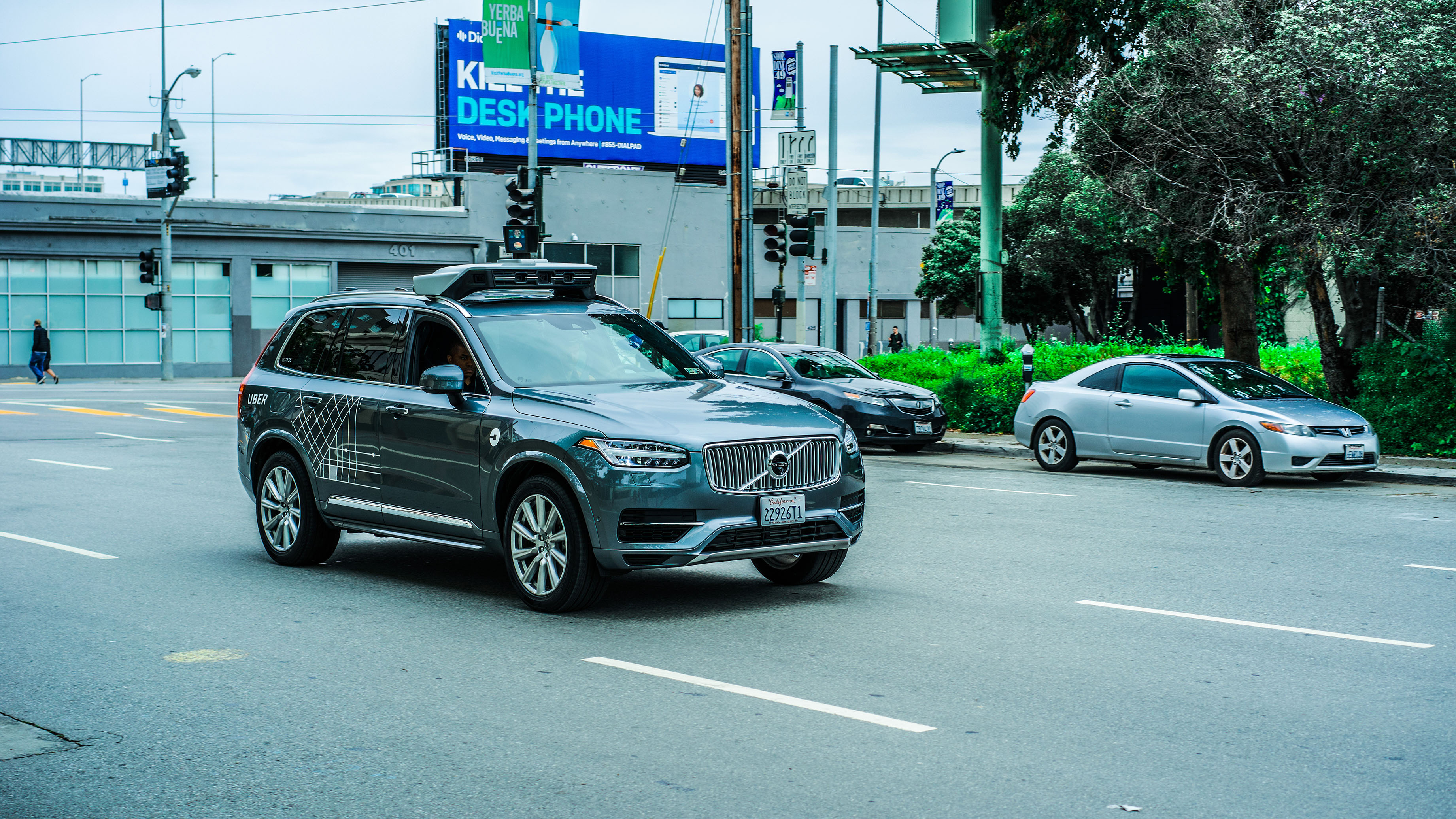 A self-driving Volvo SUV operated by Uber driving on the street.